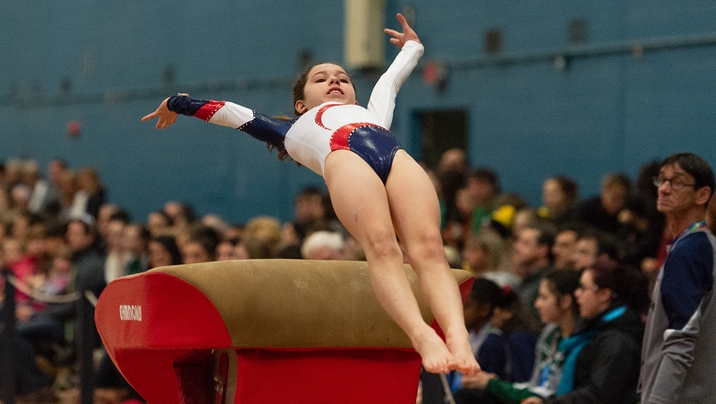 Young gymnast completing a vault